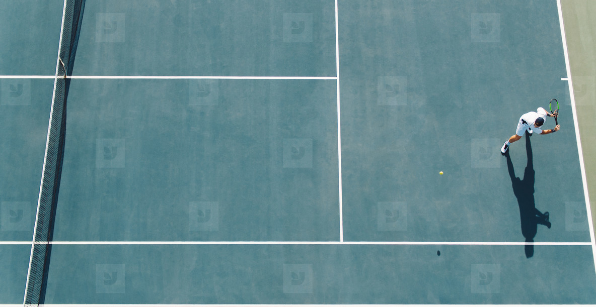 tennis player hitting backhand on hard court